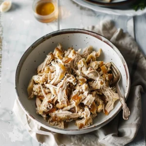 easy shredded chicken recipe in a bowl with herbs
