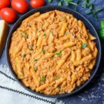 A close-up of a bowl of High Protein Creamy Beef Pasta Recipe topped with fresh basil and parsley.