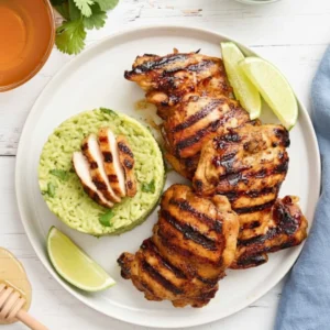 Grilled Honey Lime Chicken and Avocado Rice Stack served on a white plate with fresh cilantro garnish.
