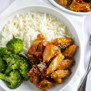 Plated bowl of Easy Teriyaki Chicken Recipe garnished with sesame seeds and scallions.