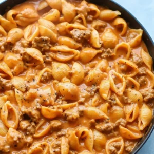A close-up shot of a bowl of creamy beef and shells pasta ready to be served, highlighting the velvety sauce.