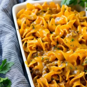 Easy Beef Noodle Casserole in a glass baking dish, fresh from the oven with a melted cheese crust.