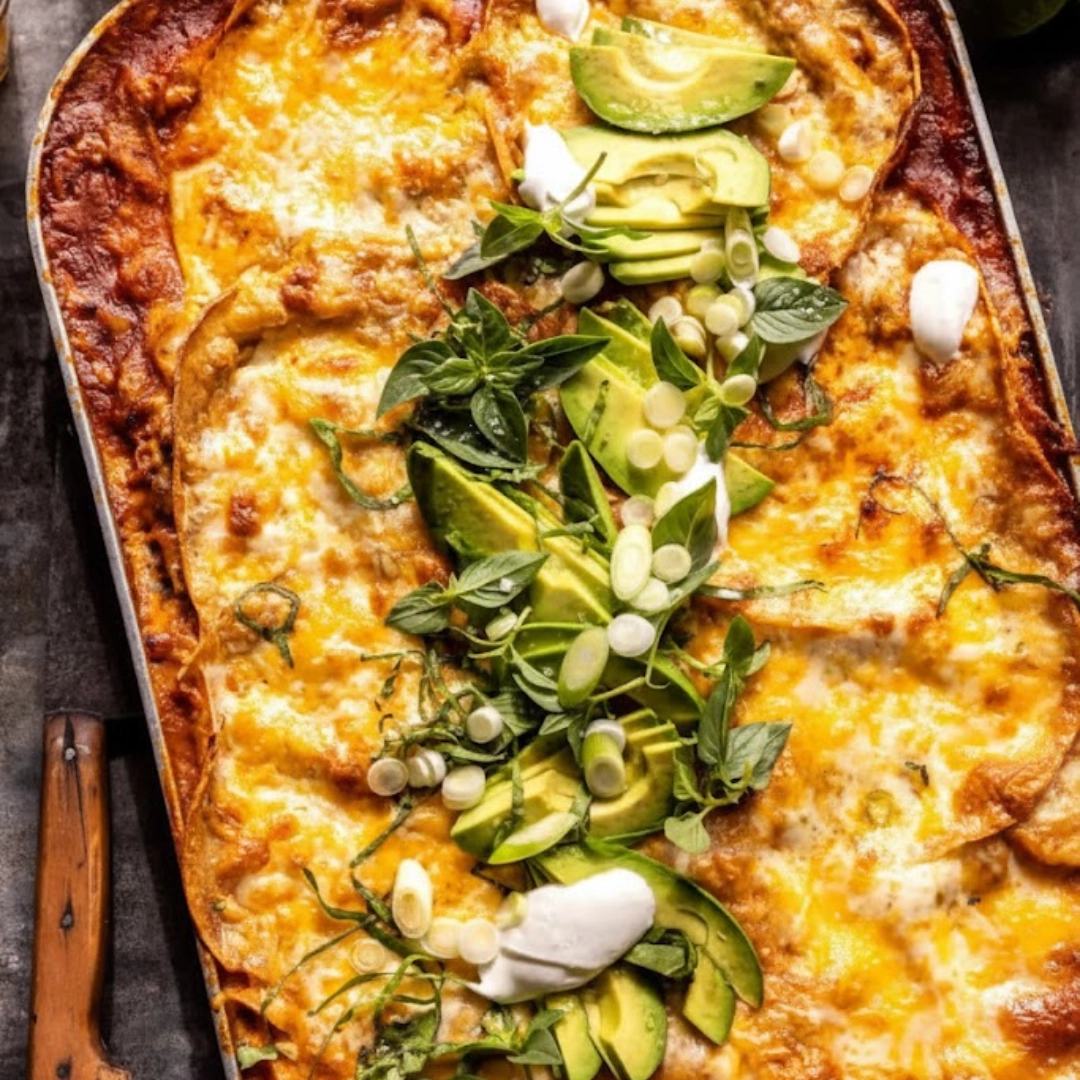 Stacked slices of saucy Beef Enchilada Casserole with melted cheese and fresh cilantro.
