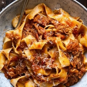 A bowl of rich Slow Cooker Italian Beef Ragu served over pappardelle pasta and topped with fresh herbs.