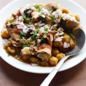 A beautifully plated and garnished bowl of the ultimate homemade samosa chaat recipe with chana masala and colorful chutneys.